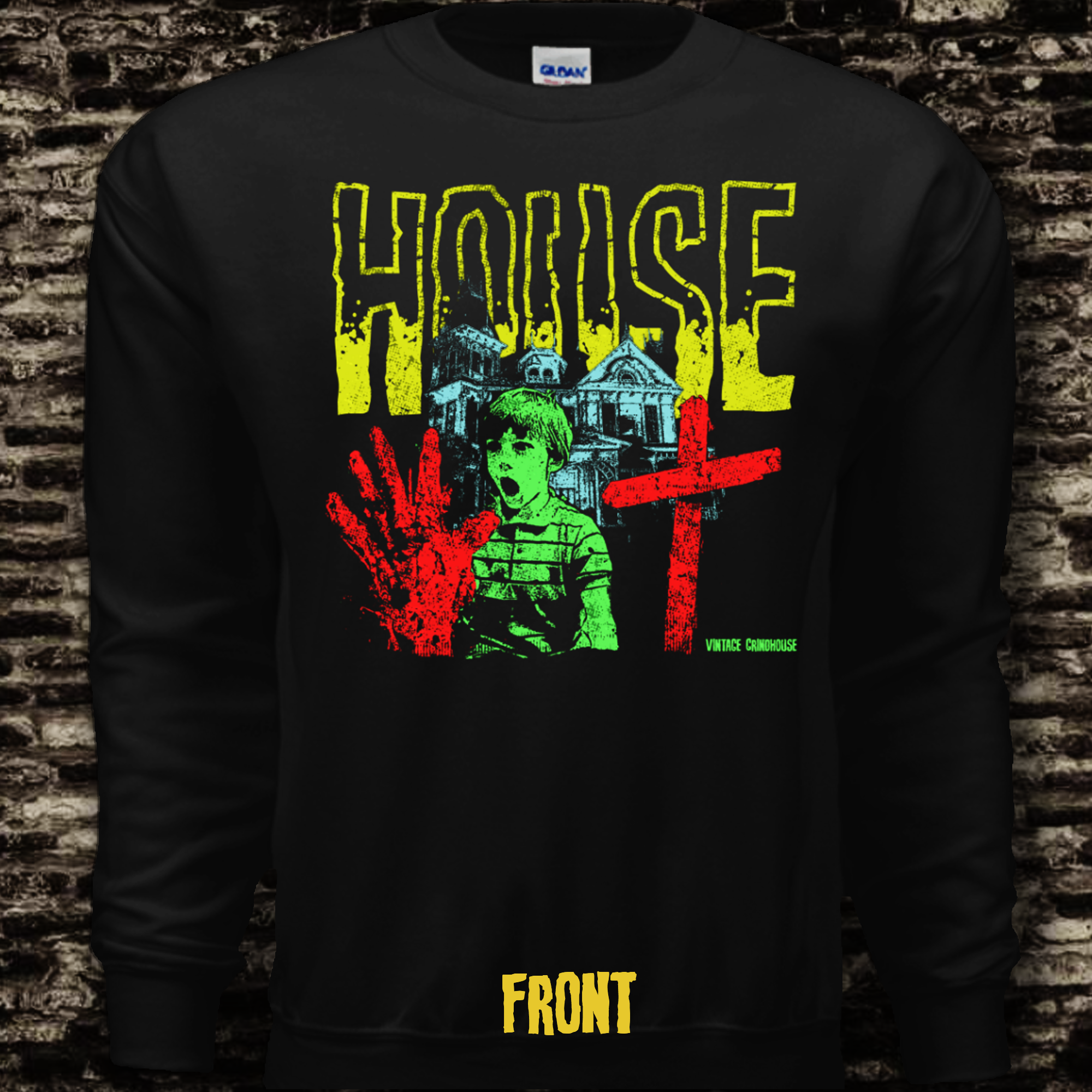 Black long-sleeve shirt with graphic design featuring a house, hand, and cross on a brick wall background.