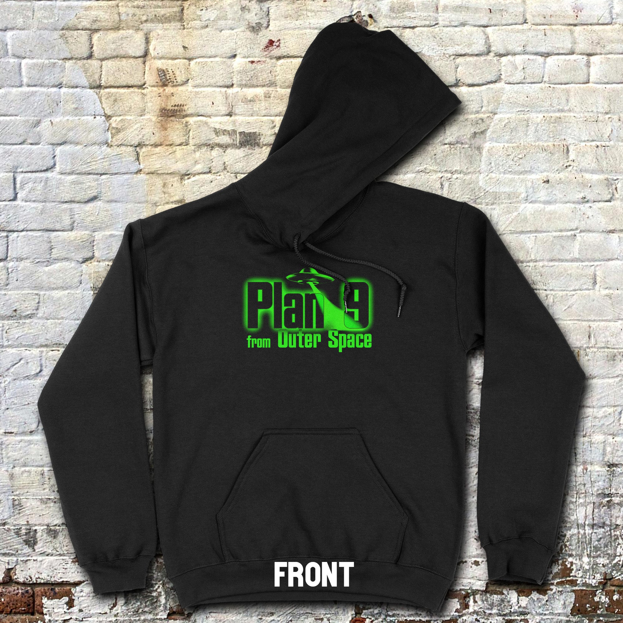 Black hoodie with glowing green Plan 9 from Outer Space hoodie - front and rear prints! logo on chest against brick wall background