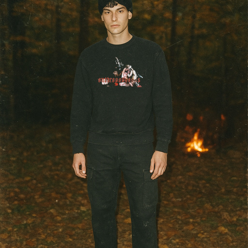 Man wearing Anthropophagus sweatshirt with eerie graphic of a grim figure and red stylized text in dark forest setting.