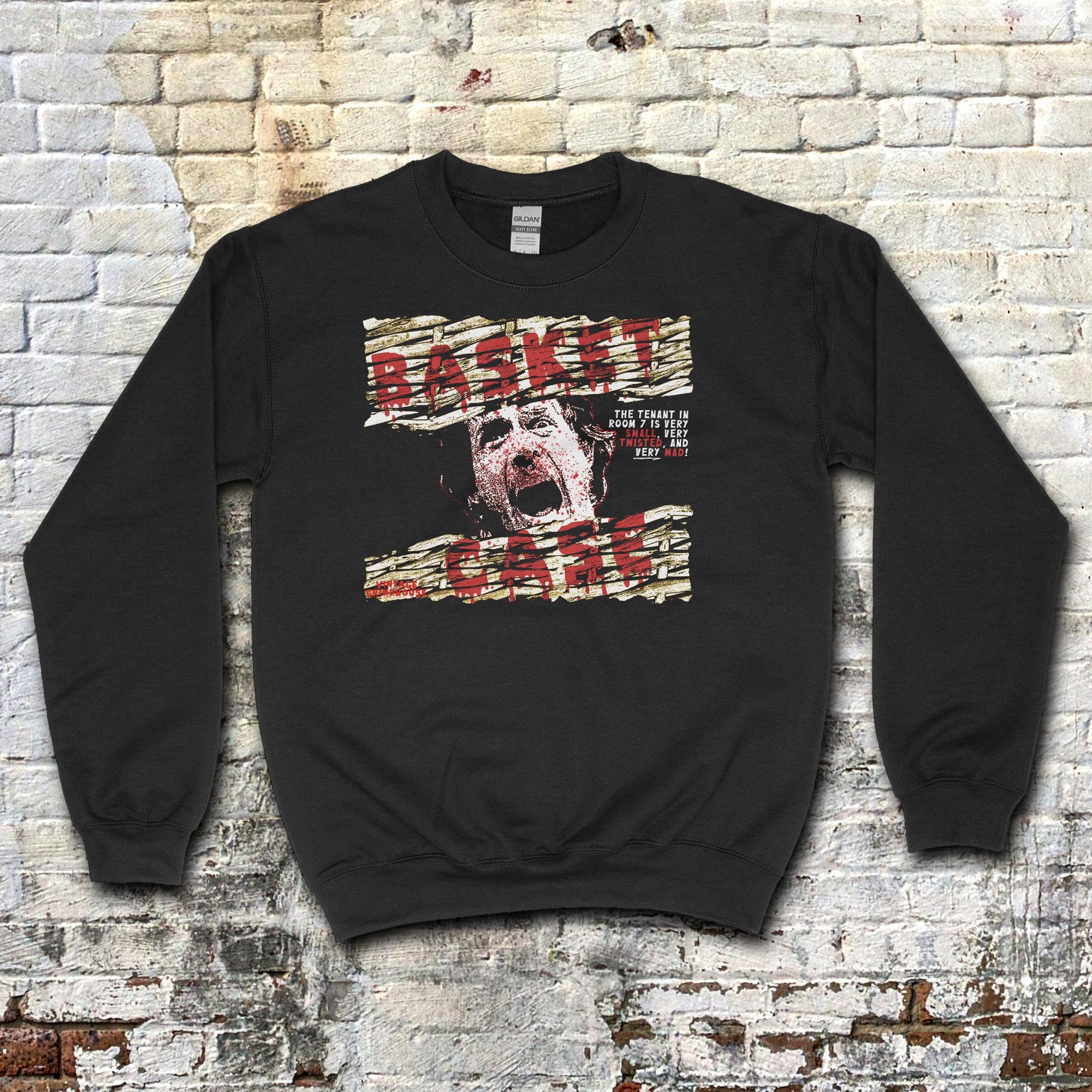 Basket Case sweatshirt with distressed graphic of a screaming face and torn text on black fabric background