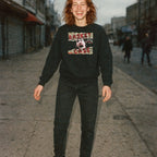 Woman standing outdoors wearing Basket Case sweatshirt with distressed screaming face graphic and torn text on black fabric