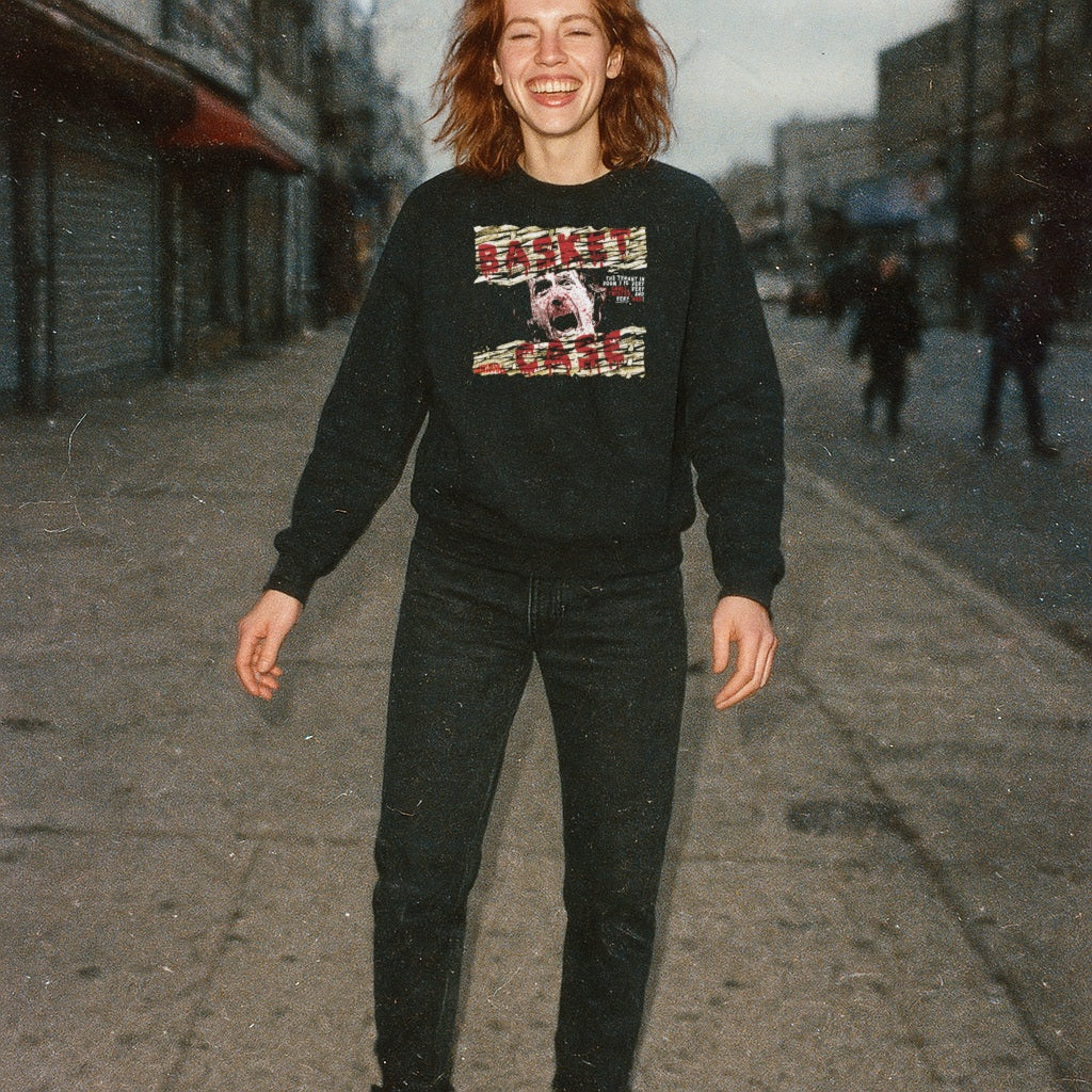 Woman standing outdoors wearing Basket Case sweatshirt with distressed screaming face graphic and torn text on black fabric