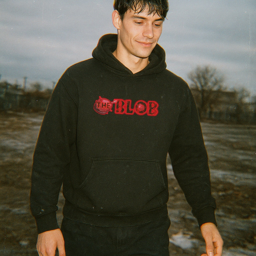 Person wearing a black hoodie with 'The Blob' logo outdoors