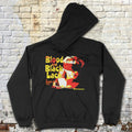 Black Blood and Black Lace hoodie with bold yellow and red vintage film graphic laid flat against brick wall background