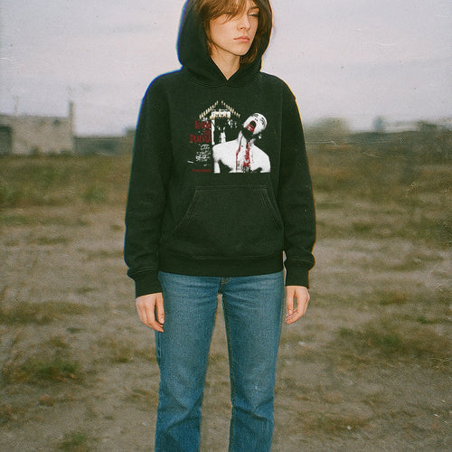 Person wearing a dark hoodie with graphic design outdoors