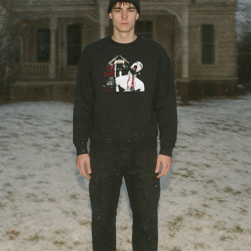 Man wearing Blood for Dracula sweatshirt with graphic of vampire biting neck and dripping blood on black fabric outdoors