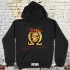 Black hoodie with a graphic design on the back against a brick wall.