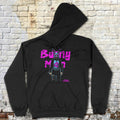Black Bunnyman hoodie with neon purple graphic of masked character holding a weapon against brick wall background