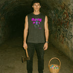 Man standing in dark tunnel wearing Bunny Man muscle tank with neon pink graphic holding an axe next to Easter basket