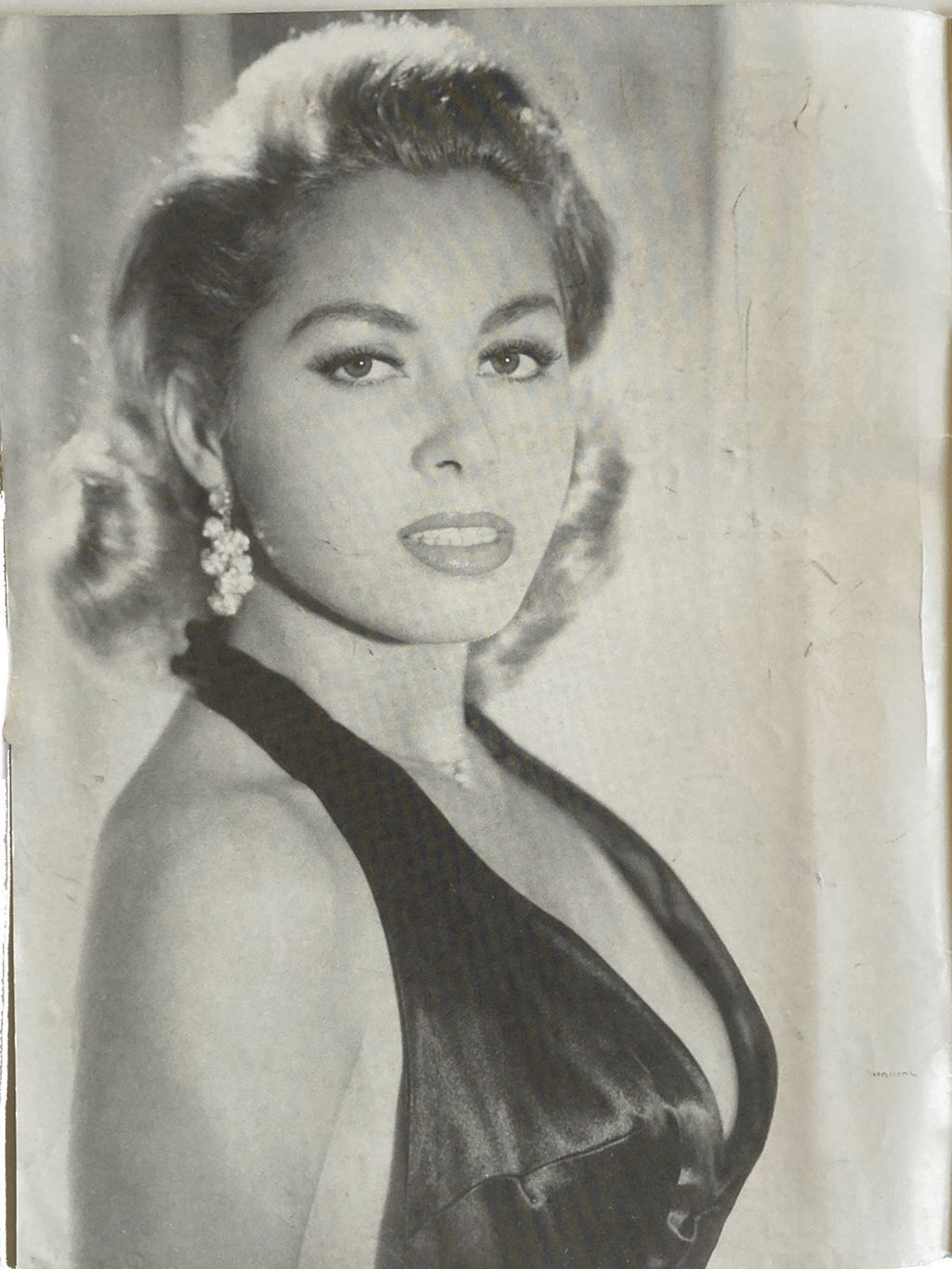 Vintage black and white photo of a woman in an elegant dress with decorative hairpiece.