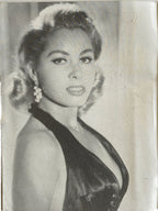 Vintage black and white photo of a woman in an elegant dress with decorative hairpiece.