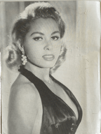Black and white portrait of a woman in an elegant dress with decorative hairpiece.