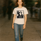 Person wearing a t-shirt with a graphic design on a blurred street background