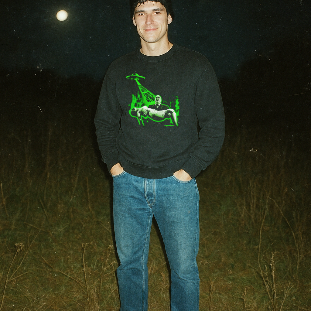 Man wearing Plan 9 From Outer Space sweatshirt with glowing green alien abduction graphic outdoors at night