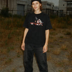 Person wearing a black t-shirt with graphic design in an industrial setting