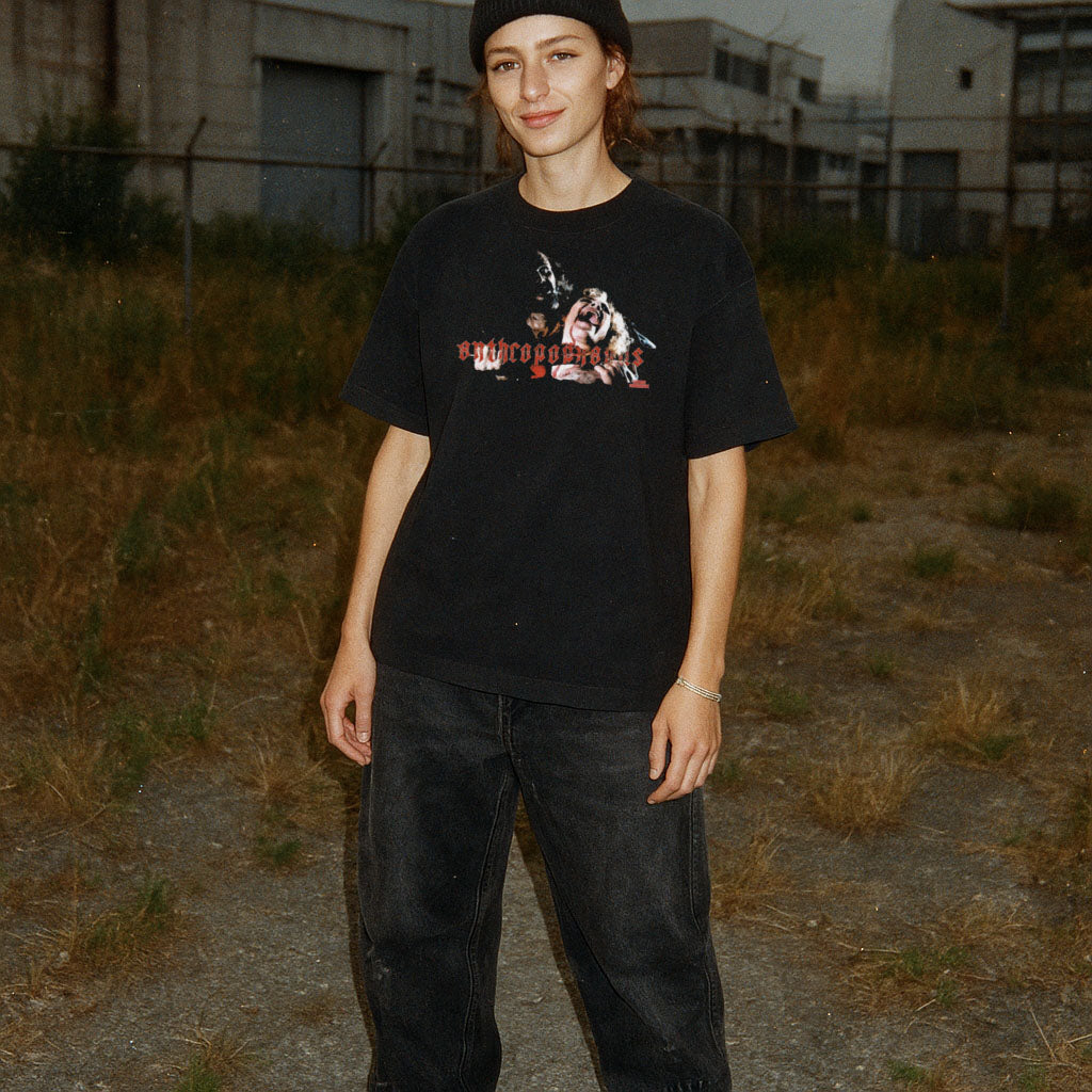Person wearing a black t-shirt with graphic design in an industrial setting