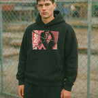 Man wearing Pieces hoodie - Torn Asunder Edition with torn photo print in red and black outdoors by chain-link fence
