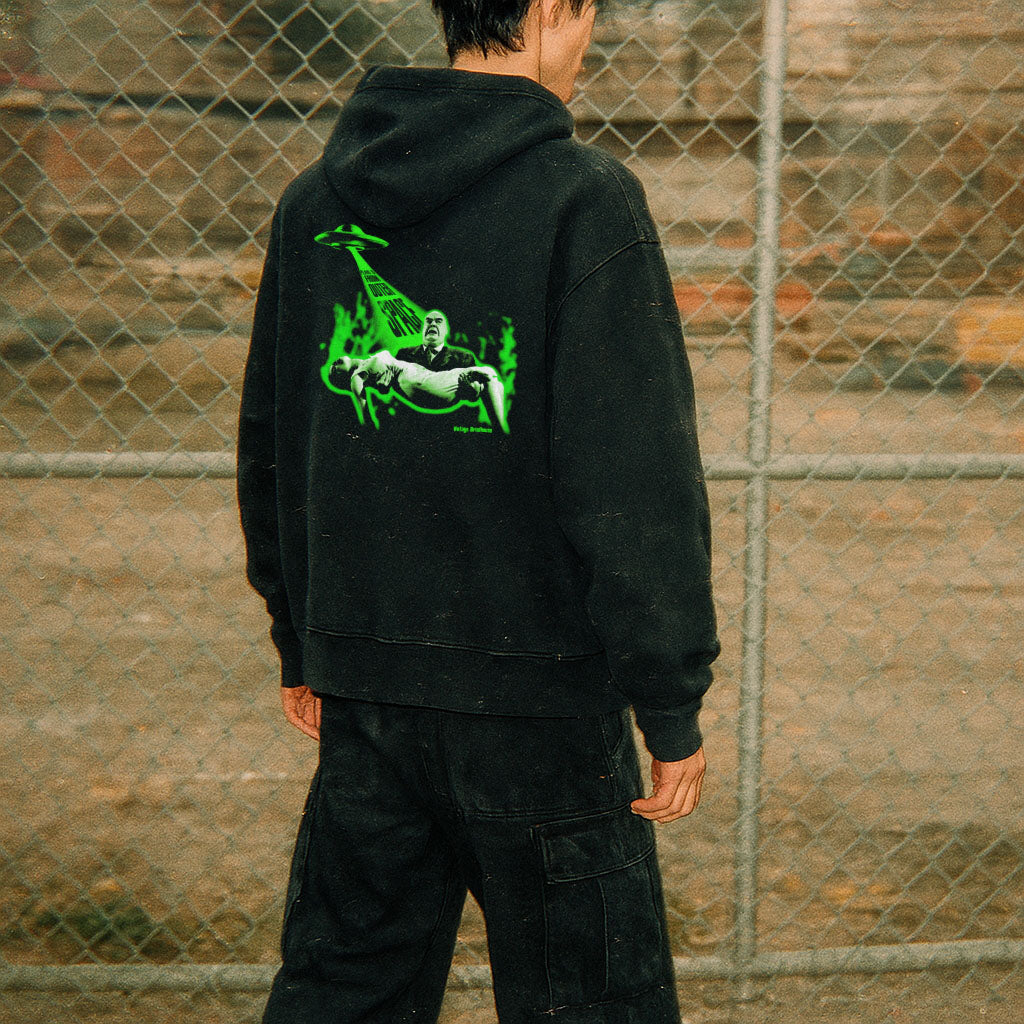 Person wearing Plan 9 from Outer Space hoodie - front and rear prints! with glowing green alien abduction design on black fabric
