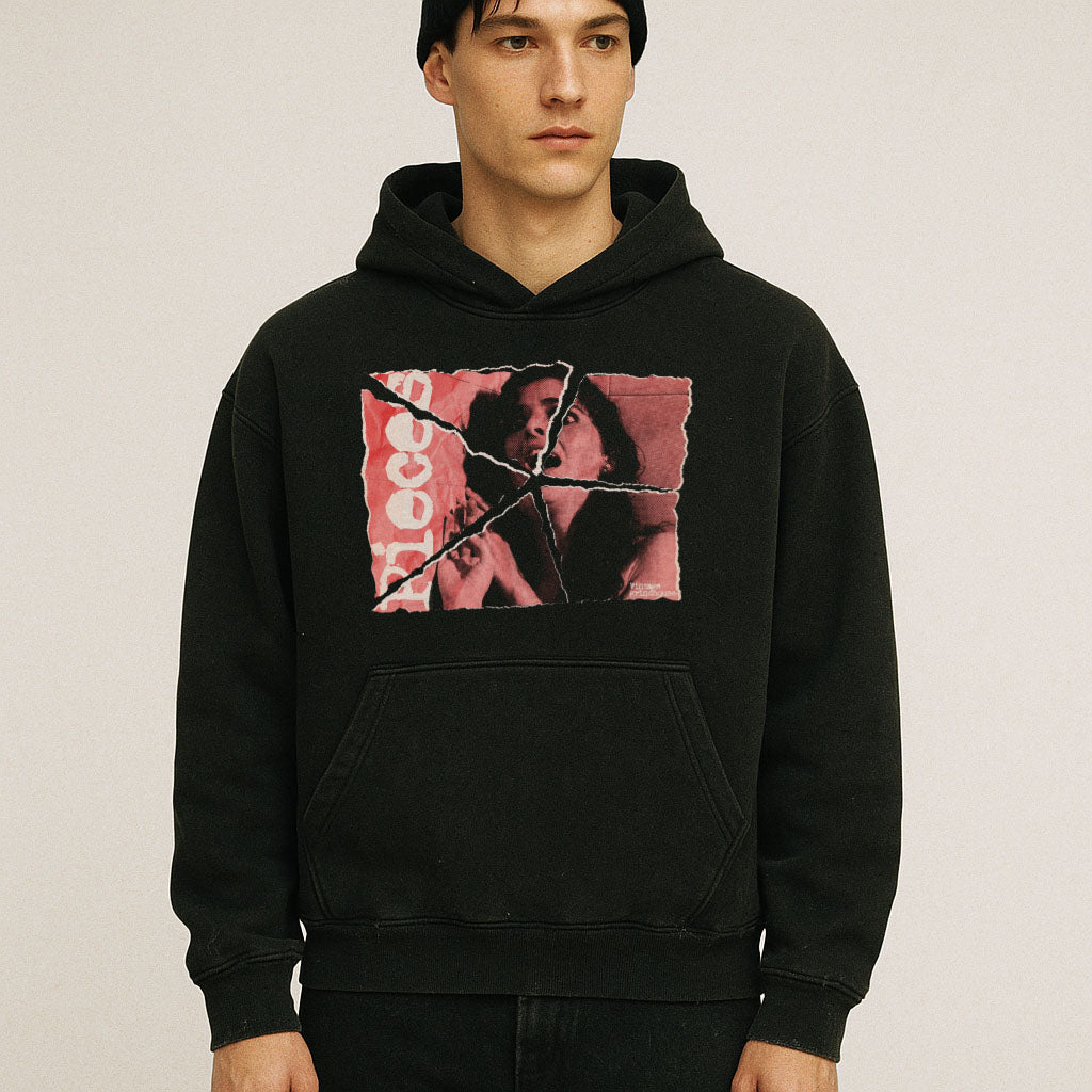 Model wearing Pieces hoodie - Torn Asunder Edition with torn vintage-style photo print on black fabric in studio setting
