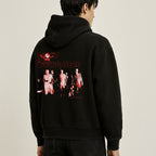 Person wearing a black hoodie with a graphic design on the back against a beige background