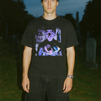 Person wearing a black t-shirt with graphic design in a cemetery