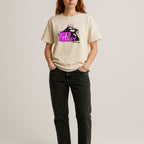 Person wearing a beige t-shirt with a graphic design and text on a plain background