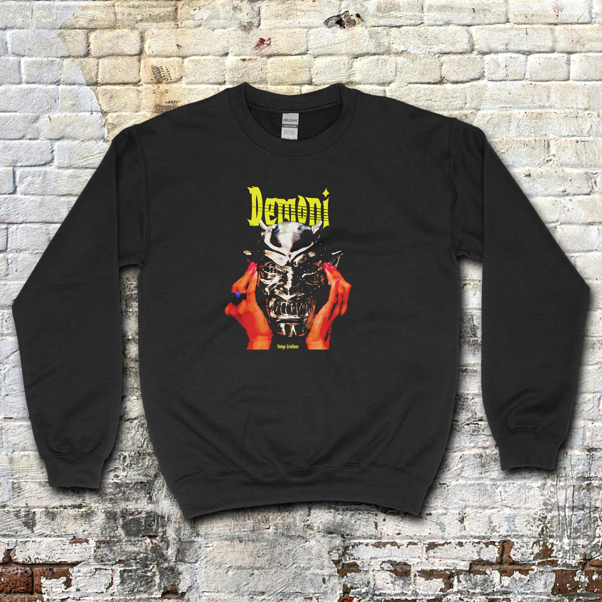 Black Demoni aka Demons sweatshirt with vivid graphic of red hands holding a silver demonic mask and yellow text