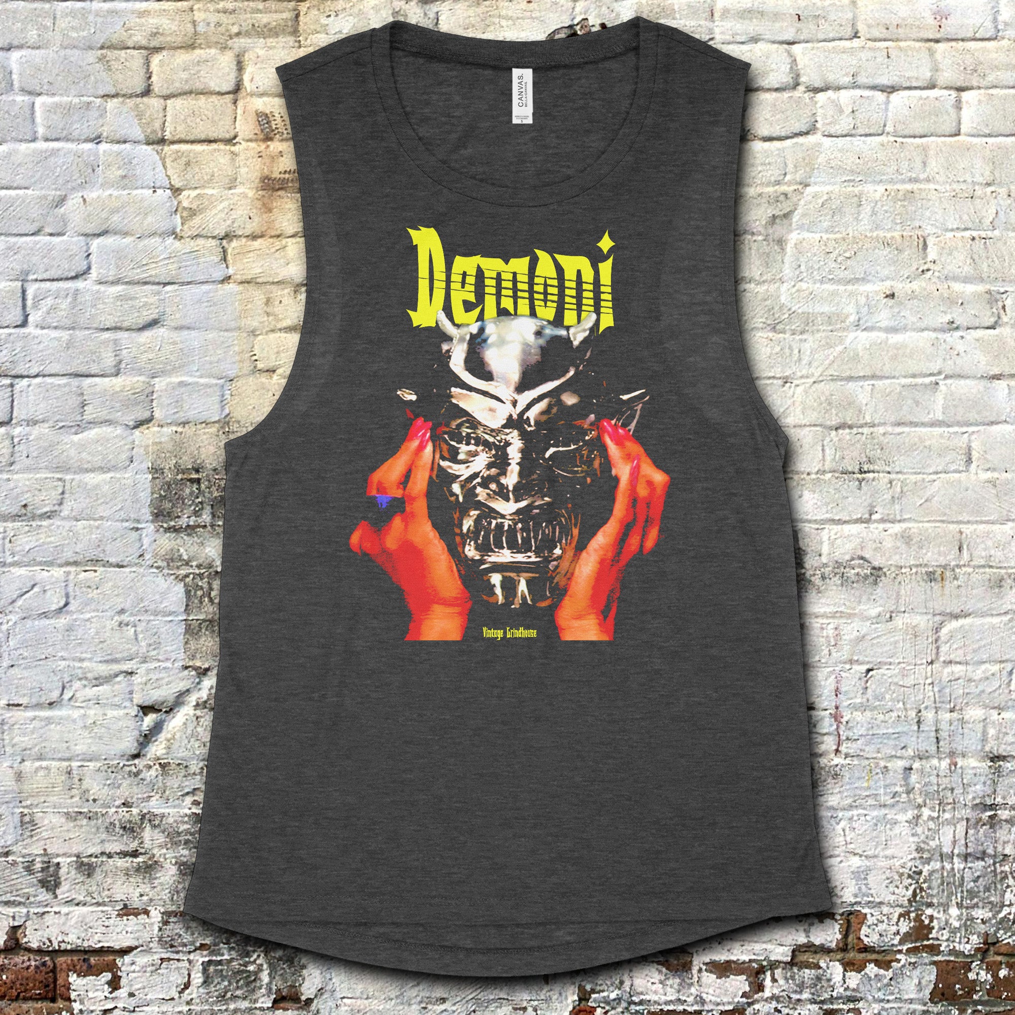 Demoni muscle tank with striking graphic of hands holding a metallic demonic skull and bold yellow text on dark fabric