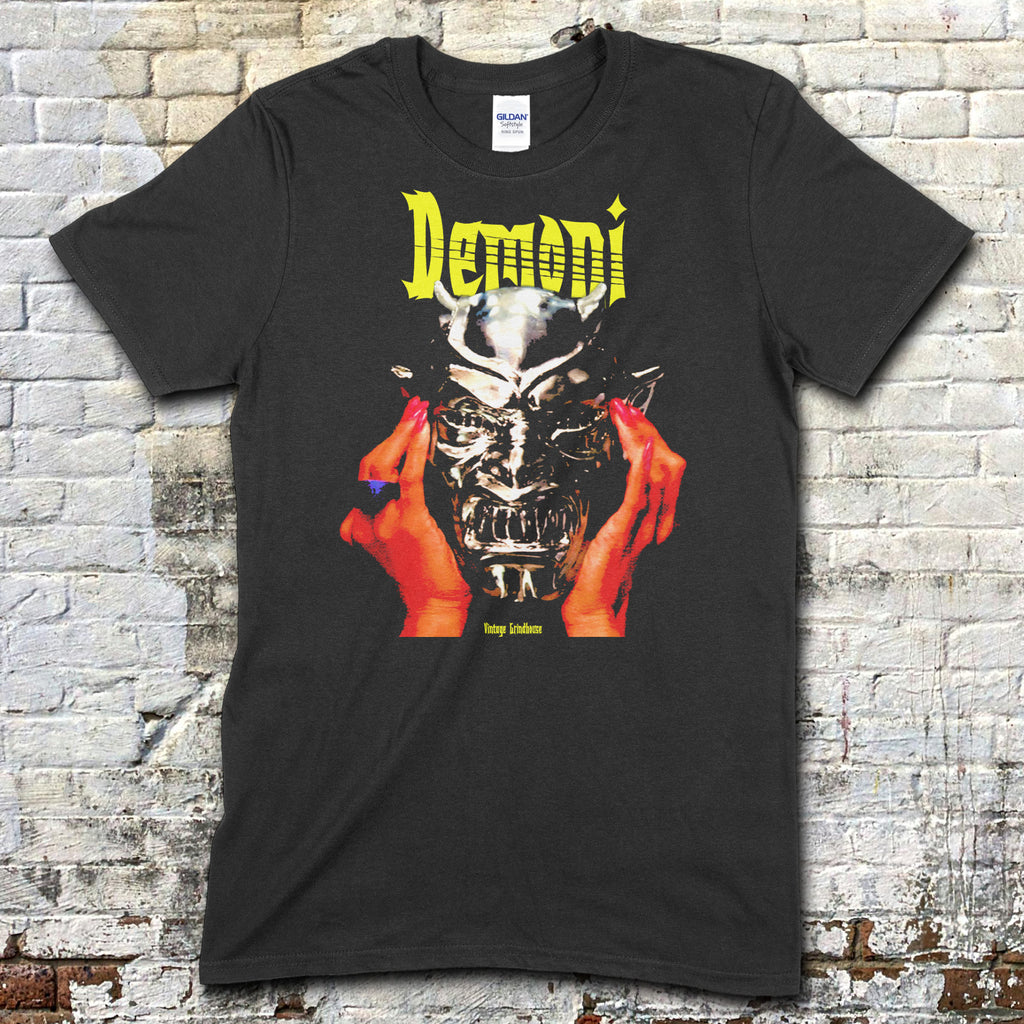 Black t-shirt featuring a graphic of hands holding a demonic silver mask with Demoni text in yellow on front