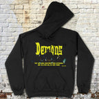 Black hoodie with yellow text and graphic design on a textured brick wall background
