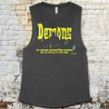 Gray tank top with yellow text against a brick wall background
