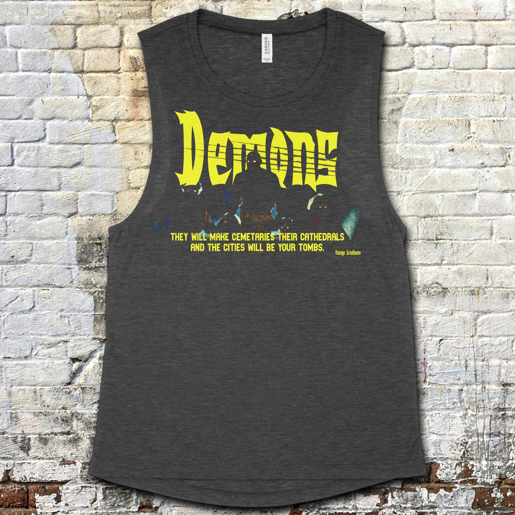 Gray tank top with yellow text against a brick wall background