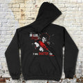 Black hoodie with graphic design on a textured brick wall background