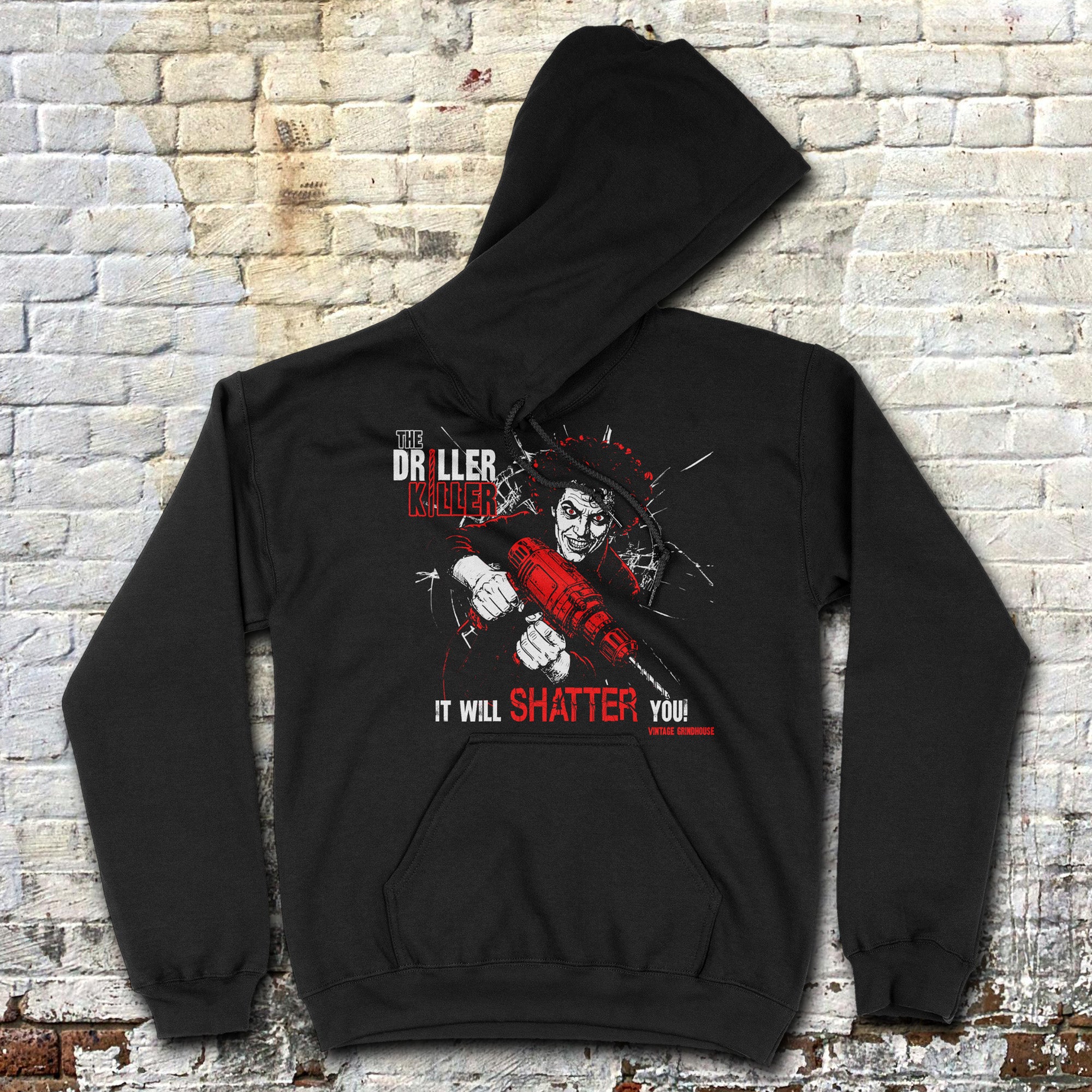 Black hoodie with graphic design on a textured brick wall background