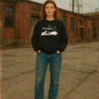 Eraserhead baby sweatshirt with monochrome baby graphic and vintage text worn by model against urban backdrop