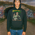 Model wearing Herbert West, Reanimator hoodie featuring vintage style horror illustration on front in outdoor urban setting