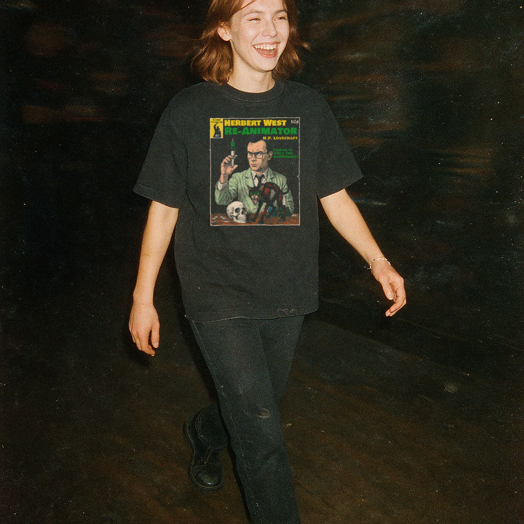 Person wearing a black t-shirt with a graphic design on a dark background