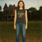 House muscle tank featuring colorful vintage horror-inspired graphic worn by model in rustic outdoor setting
