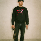 Black Last House on Dead End Street sweatshirt with red lips and vintage horror scene worn by man holding saw frame