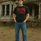Young man wearing a black Last House on the Left t-shirt with red vintage grindhouse text, standing in front of a weathered house.