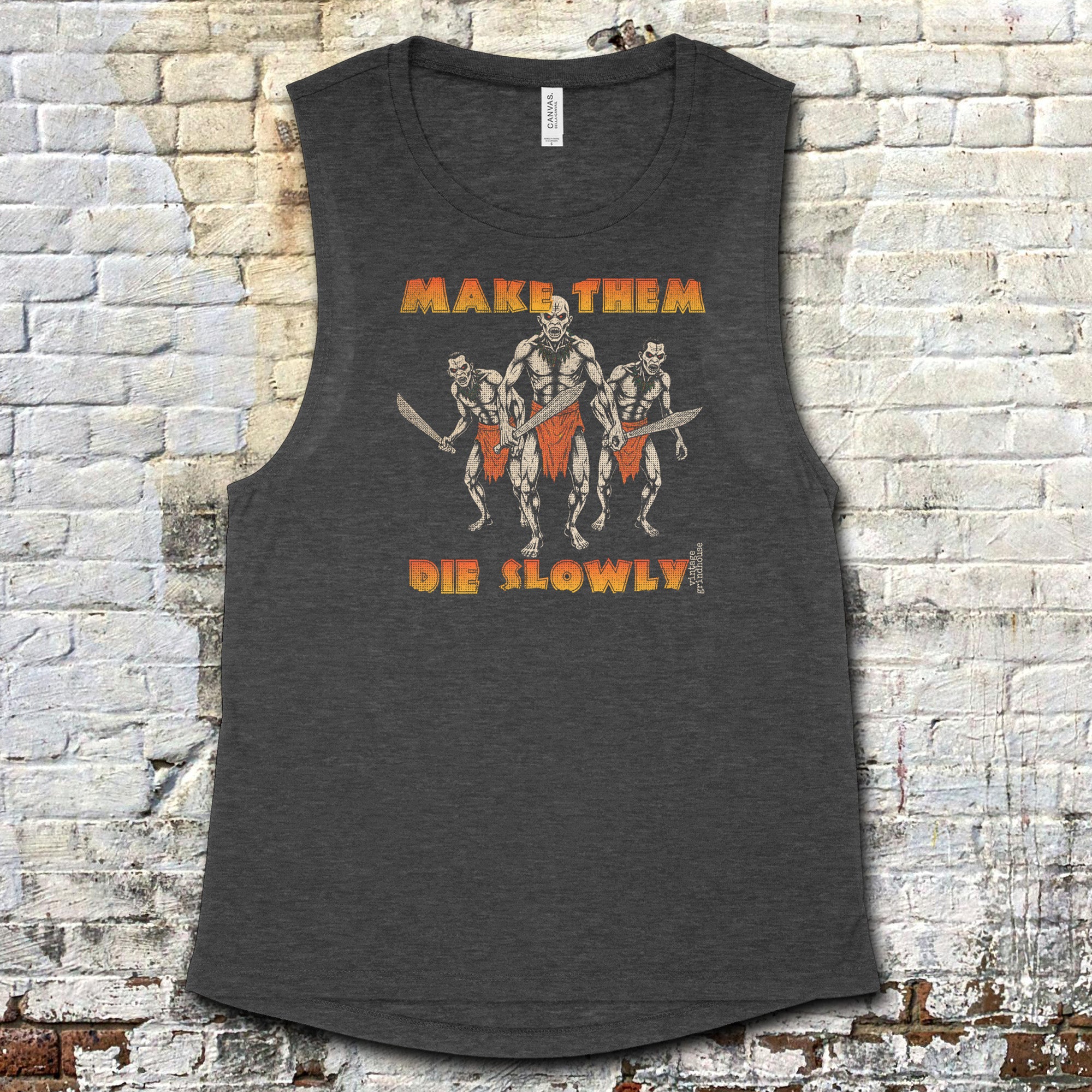 Make Them Die Slowly muscle tank with fierce warrior trio graphic and bold orange text on dark charcoal fabric
