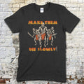 Black t-shirt featuring three savage tribal warriors with blades and Make Them Die Slowly text in orange on front