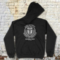 Black hoodie with a graphic design on the back against a brick wall.