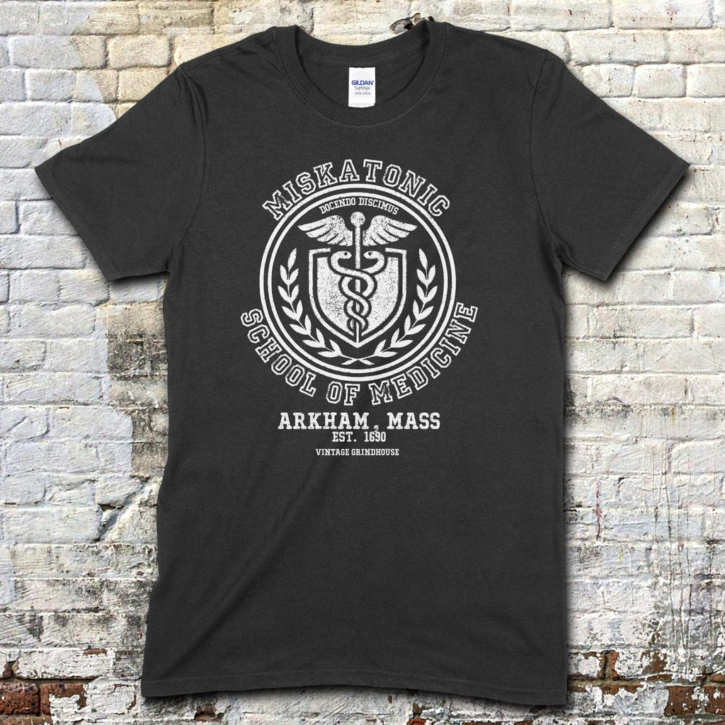 Black t-shirt featuring a vintage medical crest graphic with Miskatonic School of Medicine and Arkham, Mass text on front