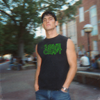 Young man outdoors wearing an H.P. Lovecraft muscle tank with neon green horror-inspired lettering on black fabric.