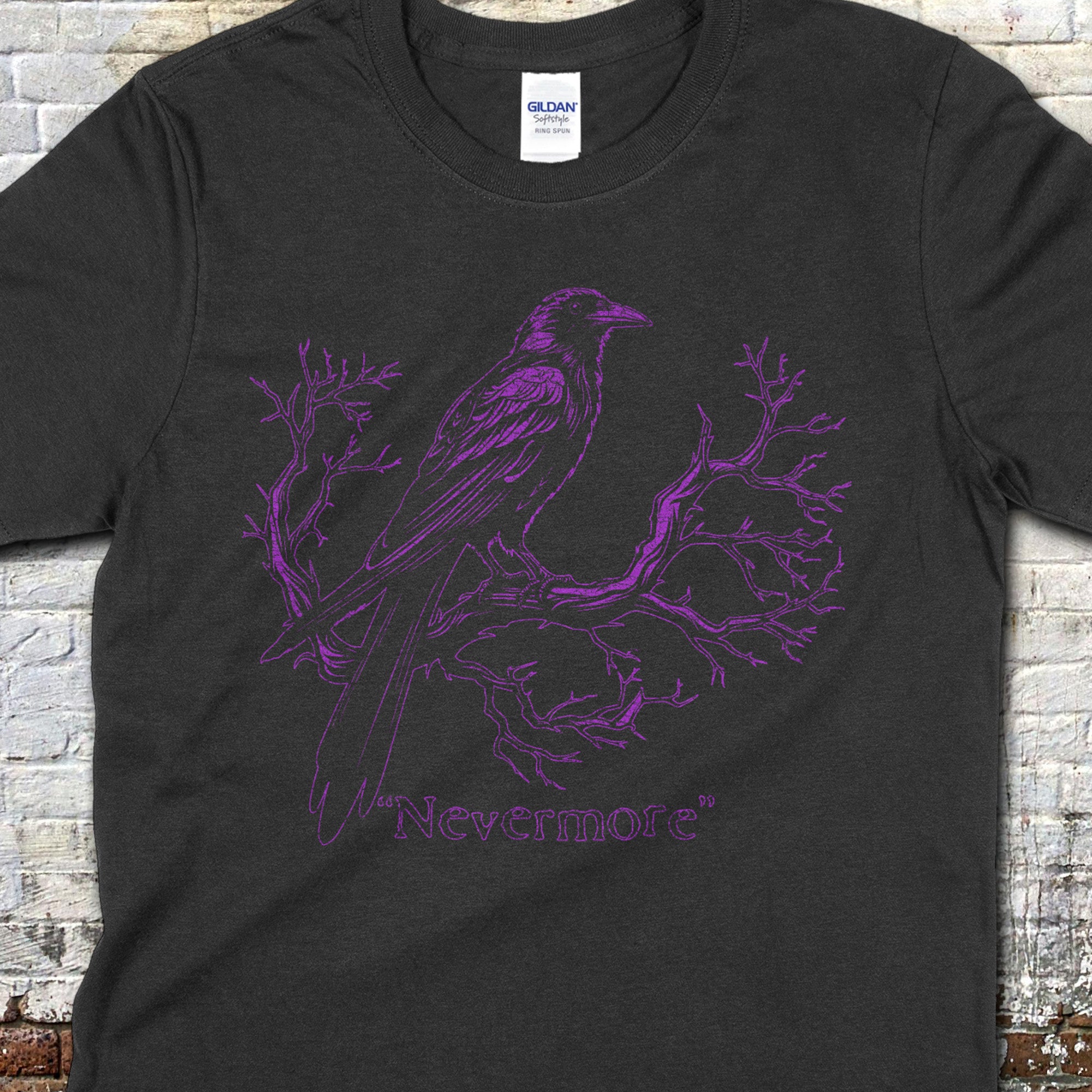 The Raven - "Nevermore" t-shirt featuring a purple raven perched on twisted branch line art on black fabric.