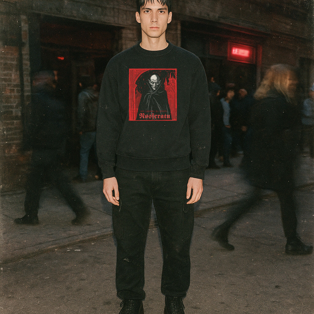 Model wearing Nosferatu: A Symphony of Horror sweatshirt with red graphic of vampire figure and stylized text outdoors at night