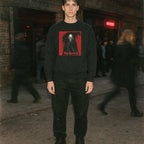 Model wearing Nosferatu: A Symphony of Horror sweatshirt with red graphic of vampire figure and stylized text outdoors at night