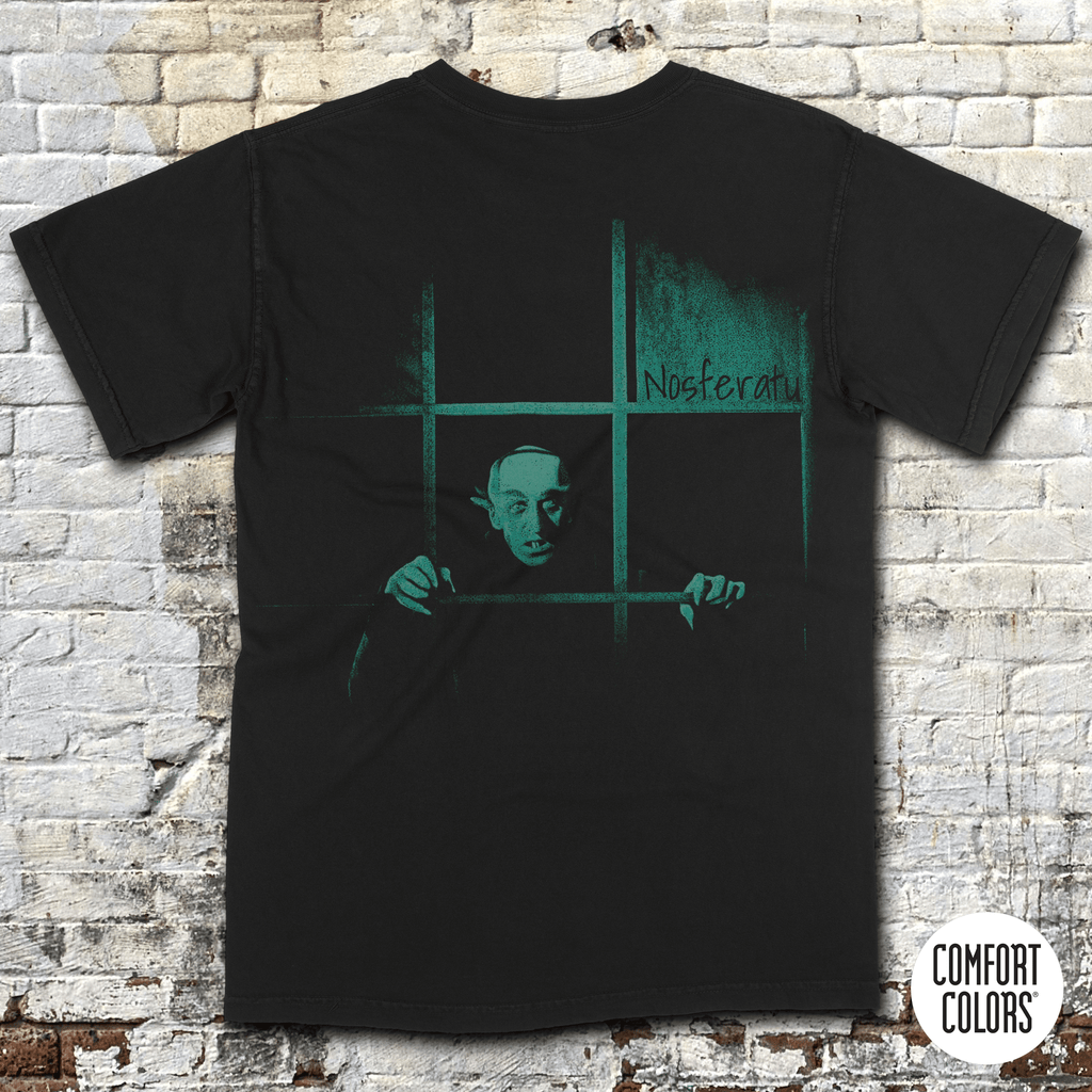 Black shirt featuring eerie greenish Nosferatu figure behind window bars with title Nosferatu: A Symphony of Horror in vintage style