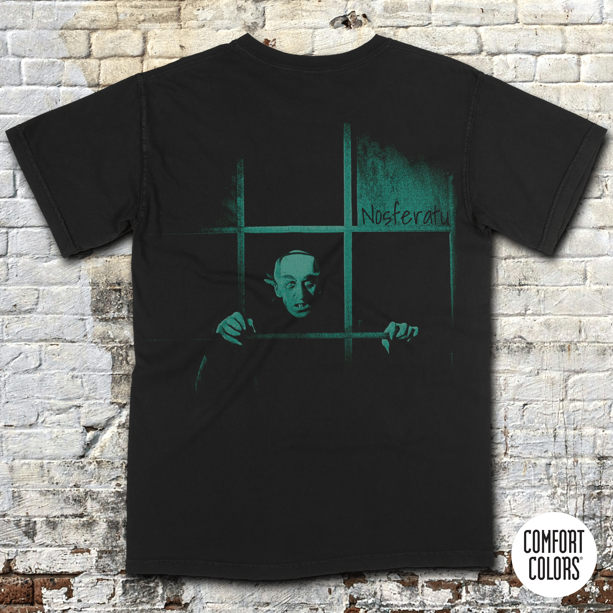 Black shirt featuring eerie greenish Nosferatu figure behind window bars with title Nosferatu: A Symphony of Horror in vintage style